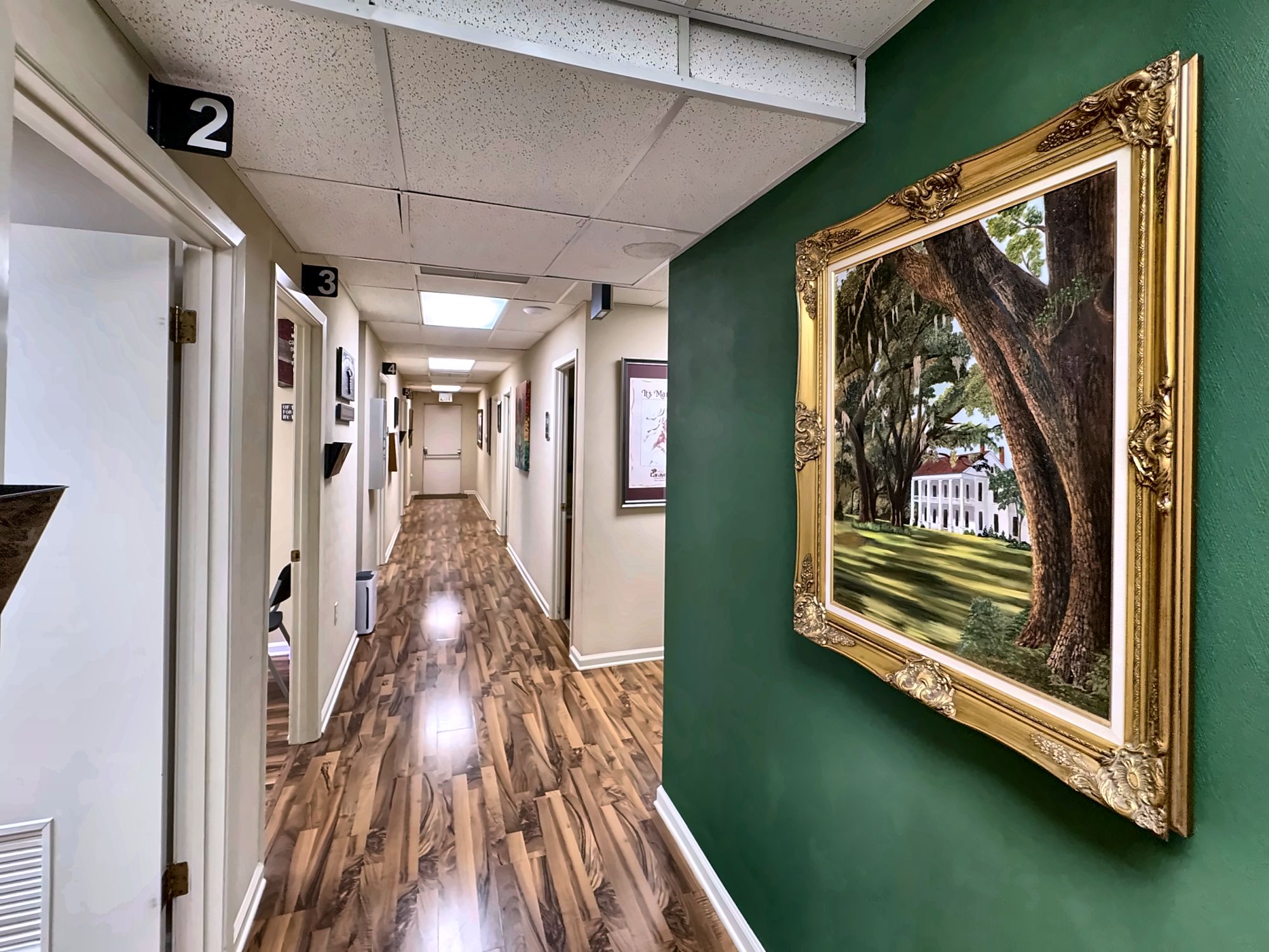 The ExpressMED hallway leading to private exam rooms, with a Louisiana oak painting