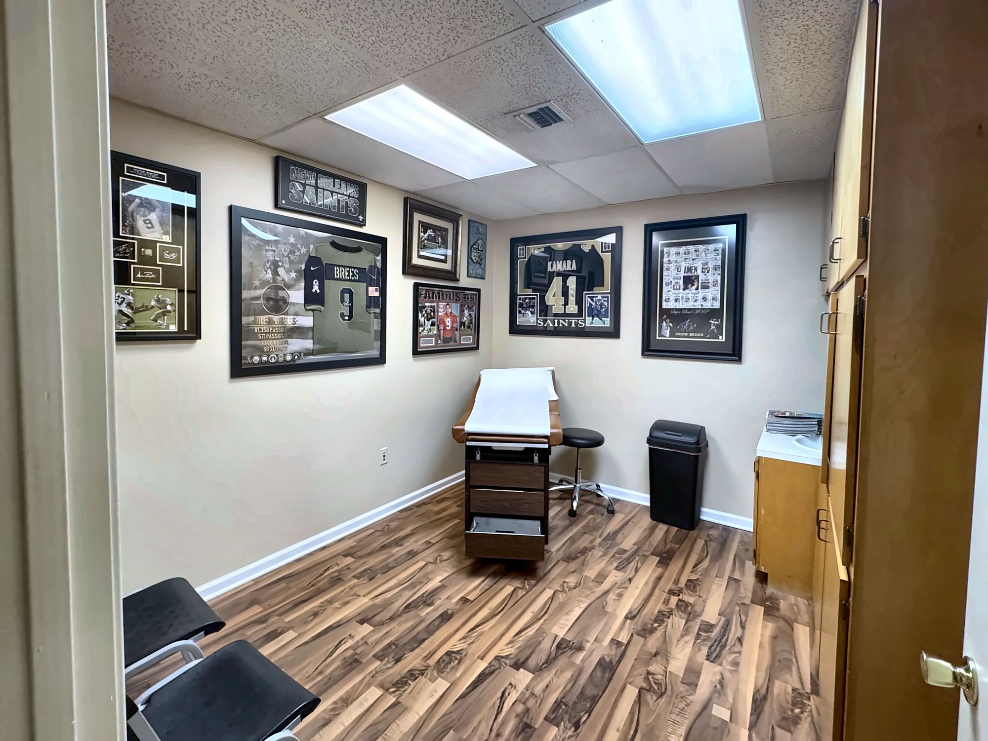 An ExpressMED exam room lined with framed football jerseys, where athletes get sports physicals
